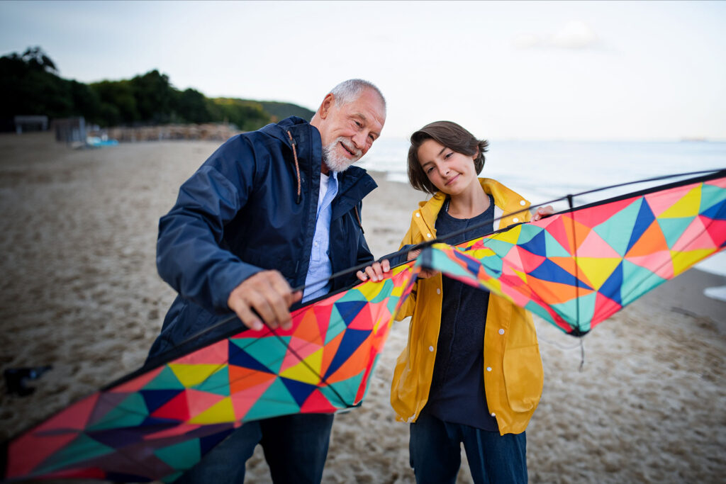 Advita Ortho Patient Education grandfather flying kite on beach with grandchild